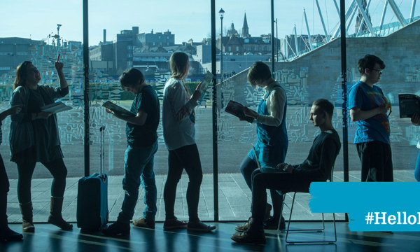 8 people standing in front of a large window