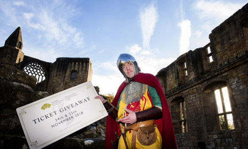 Man dressed as Robert the Bruce holds a giant ticket that reads: Ticket Giveaway
