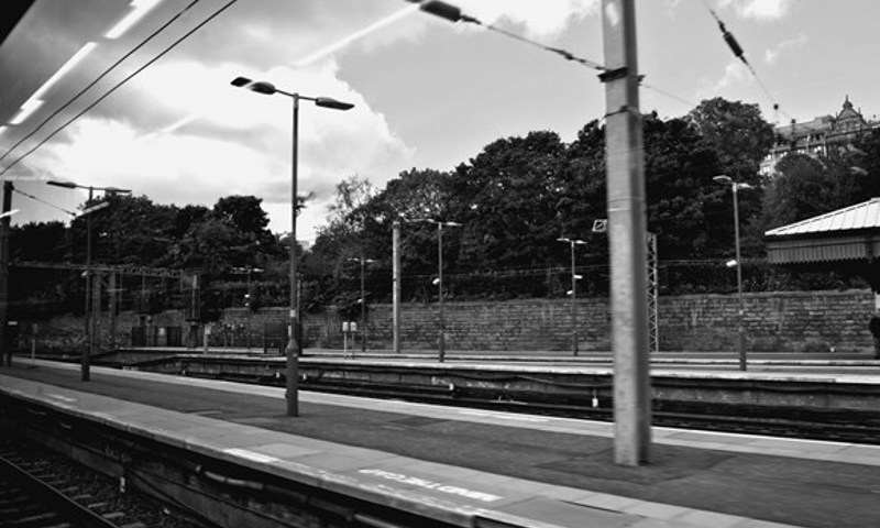 A black and white photograph of a deserted railway station.