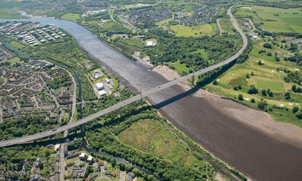 A large bridge over a river on a partially cloudy day.