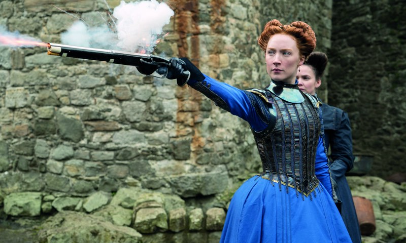 Saoirse Ronan who plays Mary Stuart firing a gun and Eileen O’Higgins in the background who plays her attendant, Mary Beaton