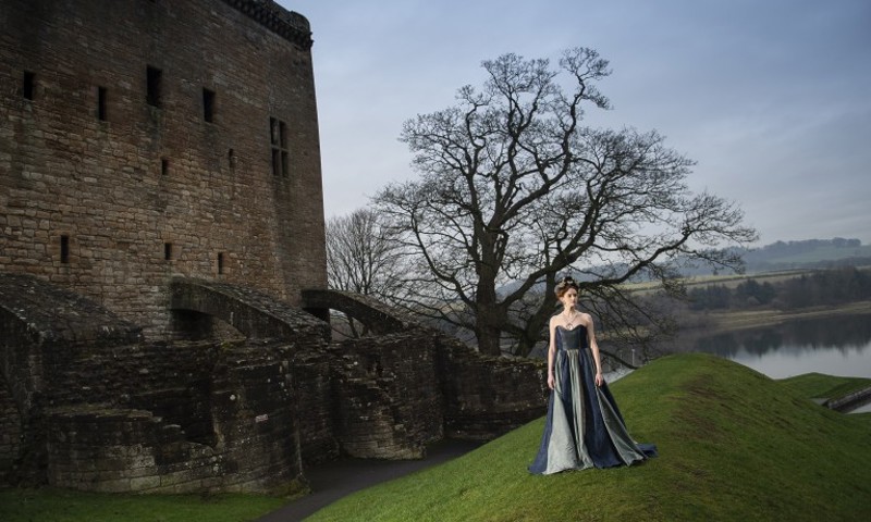 A model wearing fashion inspired by Mary Queen of Scots poses for a photo-shoot outside Linlithgow Palace