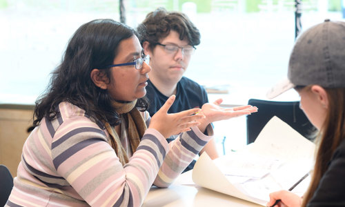 A group of young people sitting at a table work together on a local heritage project.