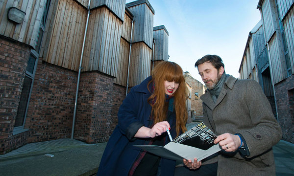Two members of Historic Environment Scotland's Casework team look through a new policy document surrounded by modern buildings.