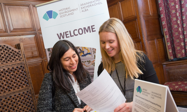 A staff member helps a candidate fill out an application.