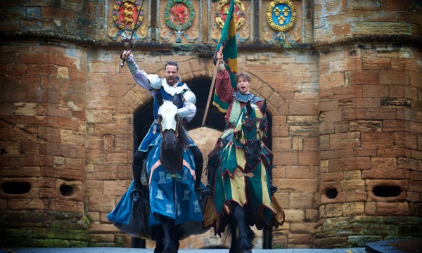 Two knights on horseback pose in front of the gates to Linlithgow Palace ahead of a jousting tournament 
