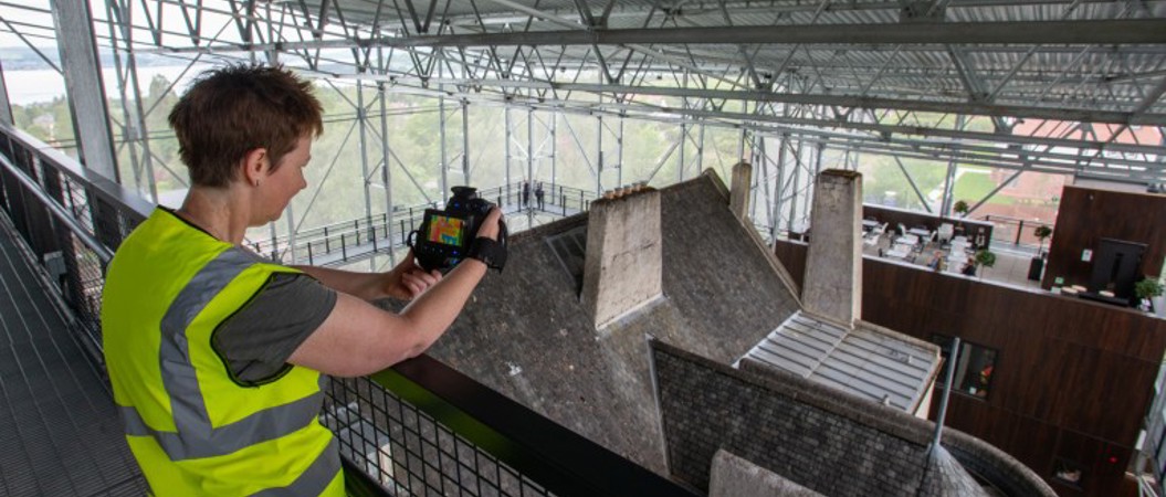 A person holding a camera up inside a historic building