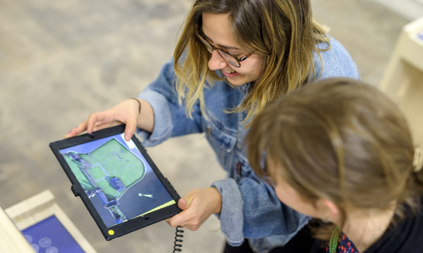 Two women use an augmented reality tablet