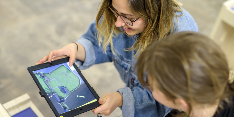 Two women use an augmented reality tablet
