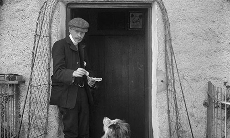 Archive photograph of a man and a dog in the doorway of Mrs Ross refreshments and lodgings 