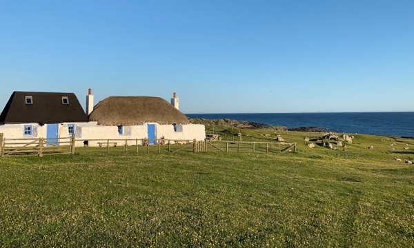 small whitewashed thatched cottage by the sea. 