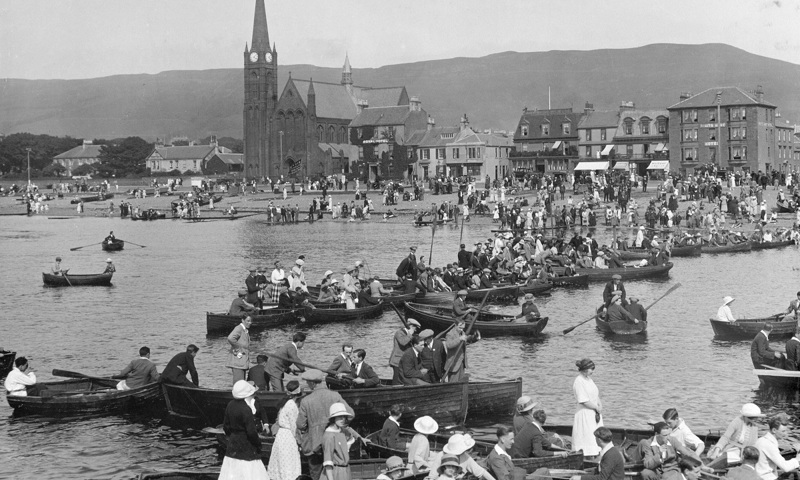 Archive photograph showing a large gathering of rowing boats at the seafront of a Scottish town