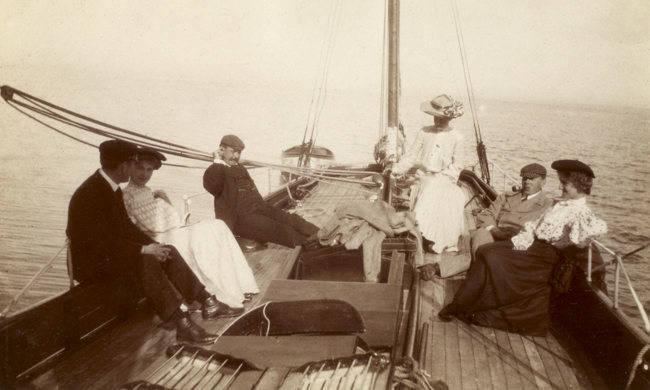 View of group on sailing boat, probably 'Gadfly' Titled: 'Sunday afternoon cruise Brodick. Jack Swan, Monty Murray, Johnson family'