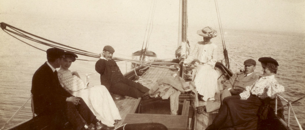 View of group on sailing boat, probably 'Gadfly' Titled: 'Sunday afternoon cruise Brodick. Jack Swan, Monty Murray, Johnson family'