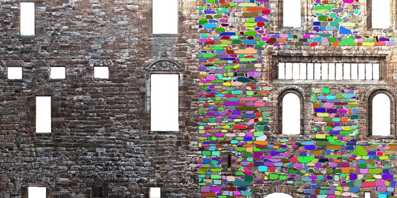 A historic wall, where some of the bricks are coloured in with bright colours