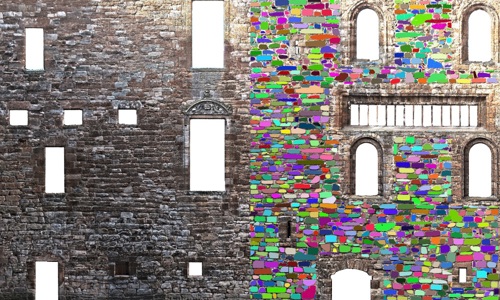 A historic wall, where some of the bricks are coloured in with bright colours