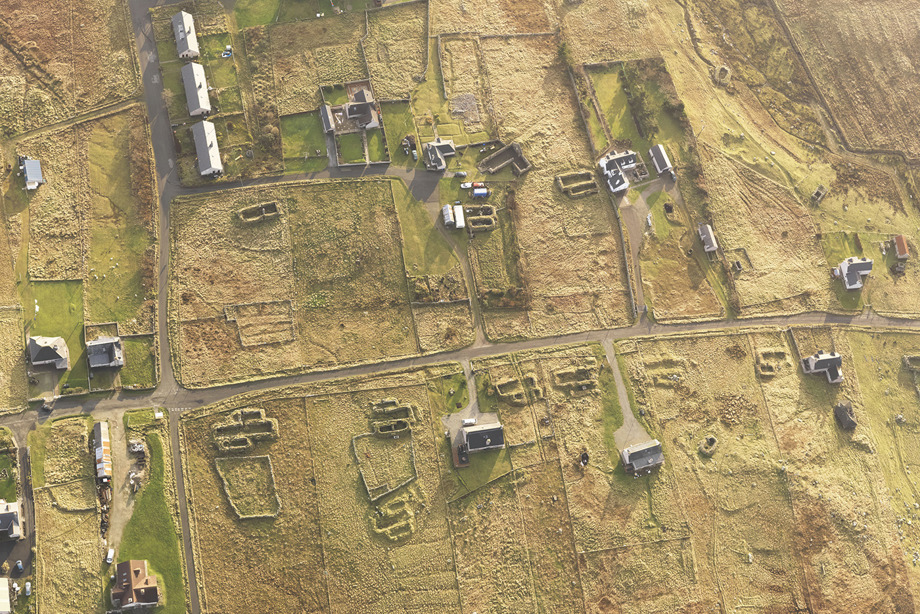 An aerial view of a small collection of buildings on a grassy field