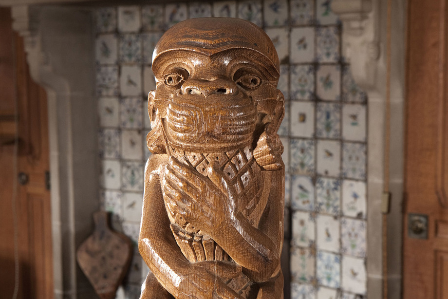 A tall, wooden pole with a monkey carved into the top
