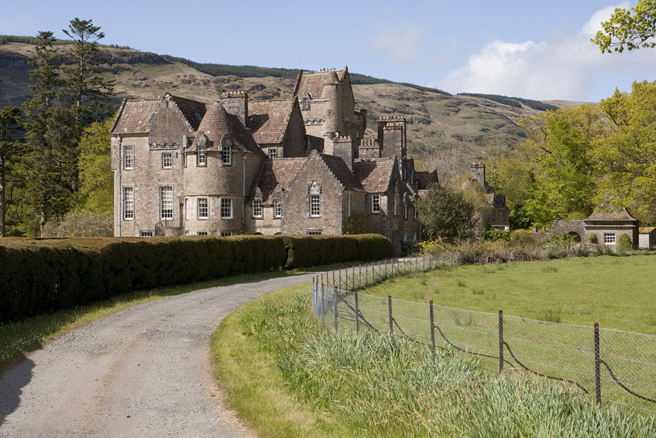 A large, historic stone house in the countryside