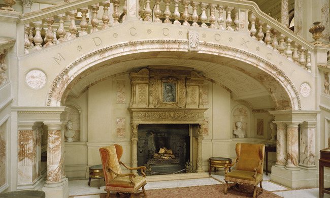 A marble staircase and fireplace, with armchairs by the fire