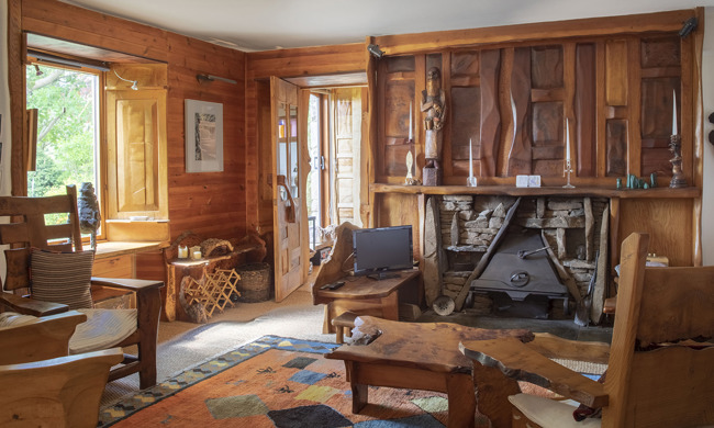 A room with wooden walls, and wooden carvings and intricately carved wooden furniture