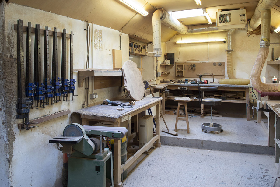 A room with work benches, hand tools, power tools and stools