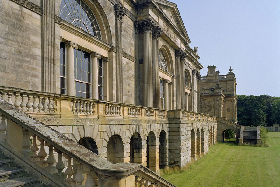 A large stone mansion, with a wide staircase leading up to the entrance