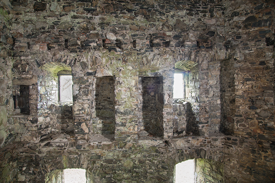 An old stone wall with multiple windows in a row