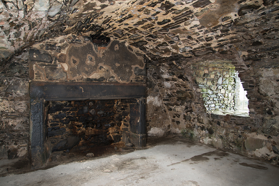 A stone room with a curved ceiling and a large fireplace