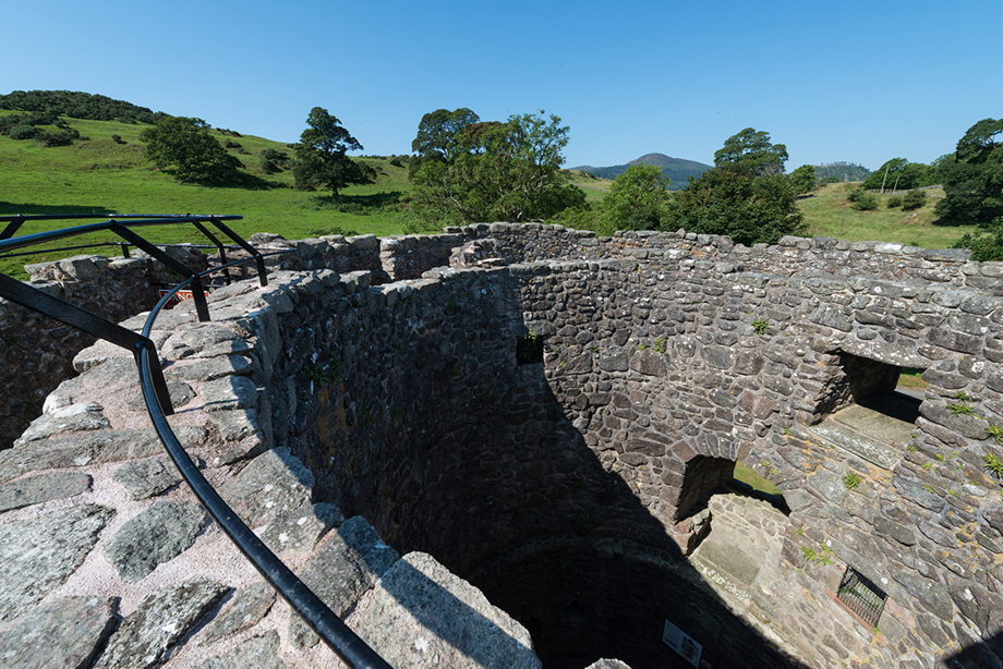 A fenced walkway around the top of a circular tower with no roof.