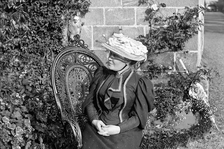Black and white photograph of a woman sitting outside Culross Abbey House, Fife.
