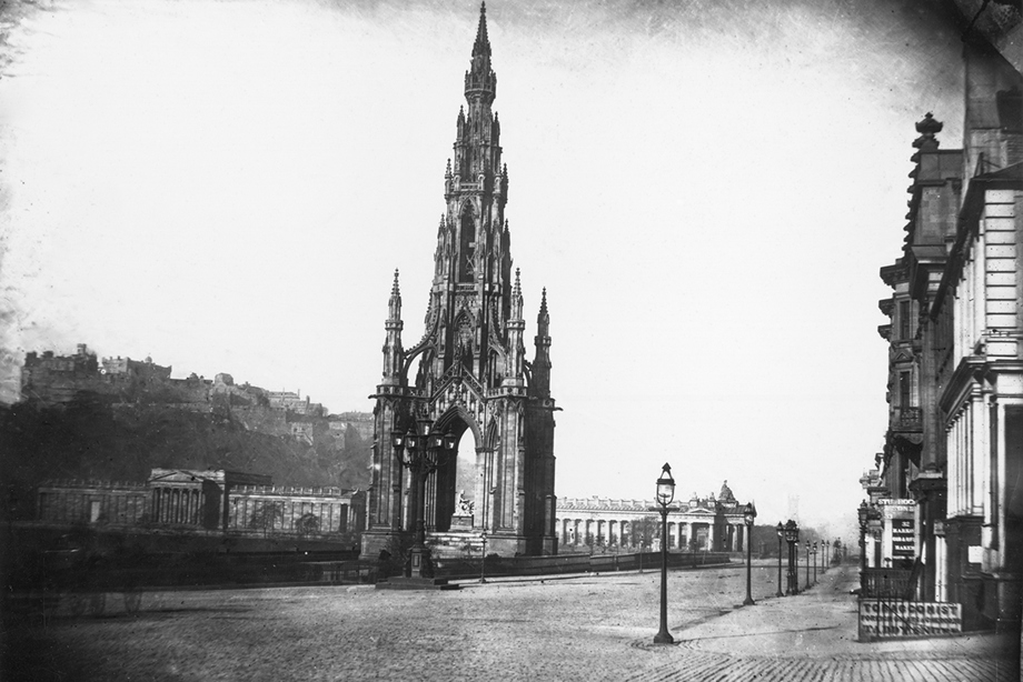 A tall, Gothic monument towering beside a large street 