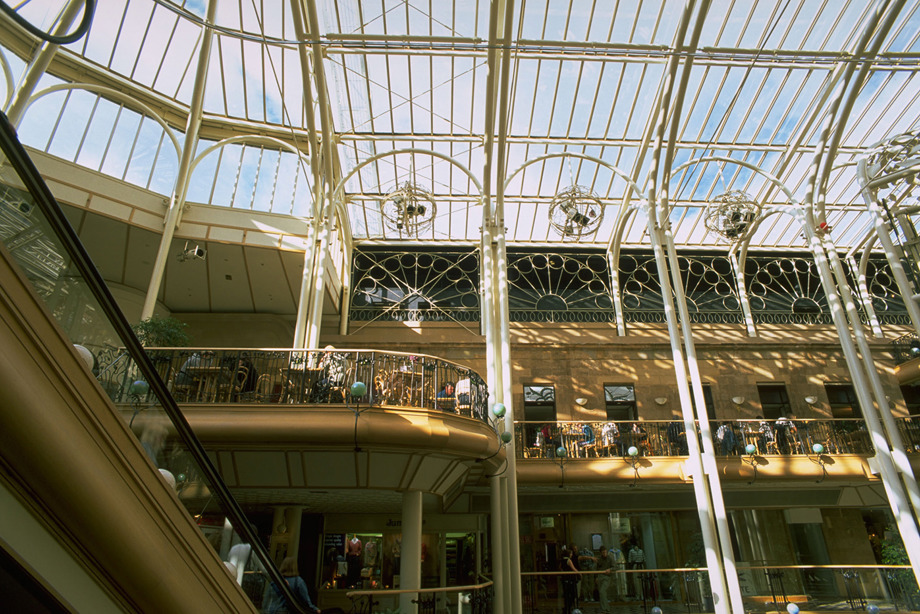 A multi-storey shopping arcade with an iron and glass roof