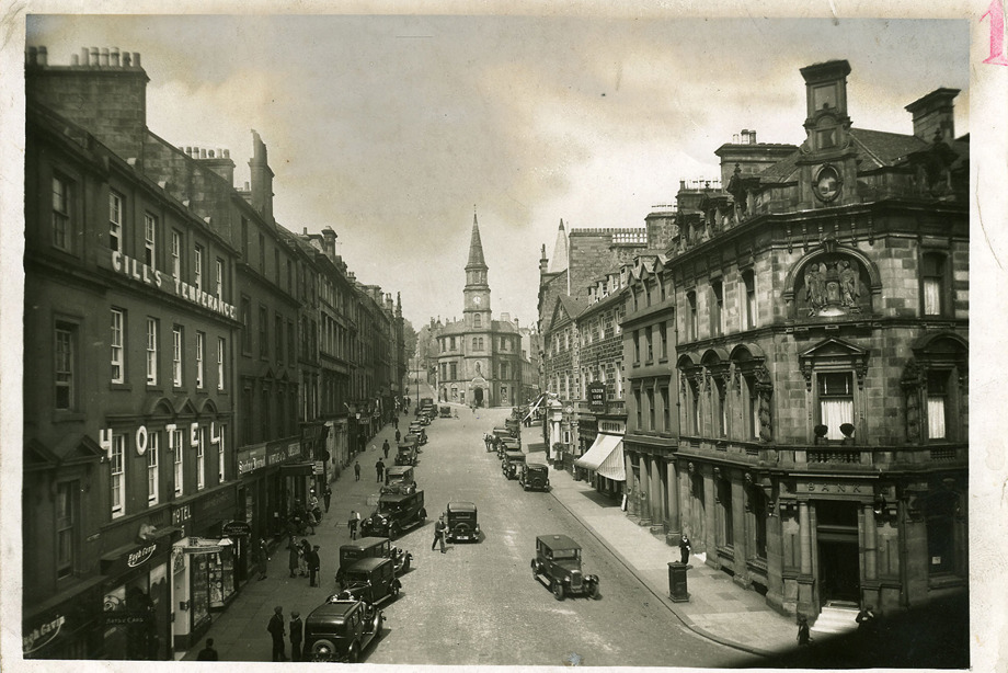 A busy main street, full of shops and cars