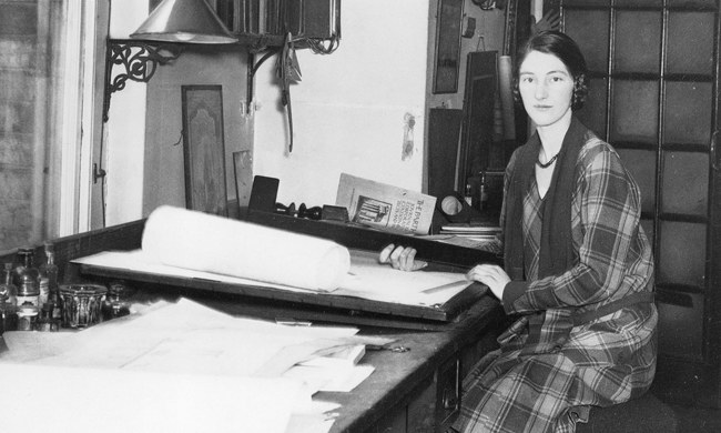 Architect Kathleen Veitch sits at a her drafting table, looking at the camera