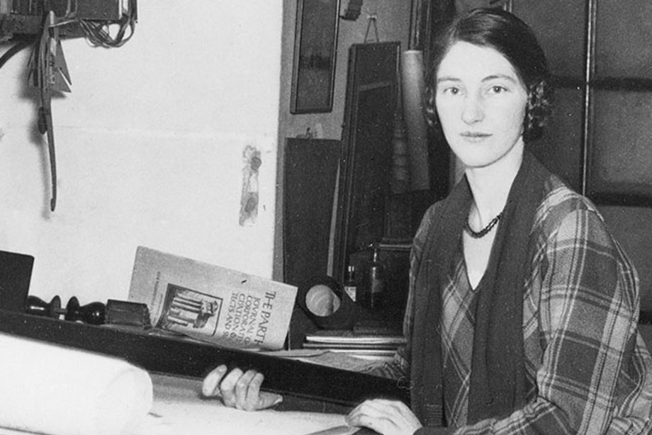 Architect Kathleen Veitch sits at a her drafting table, looking at the camera