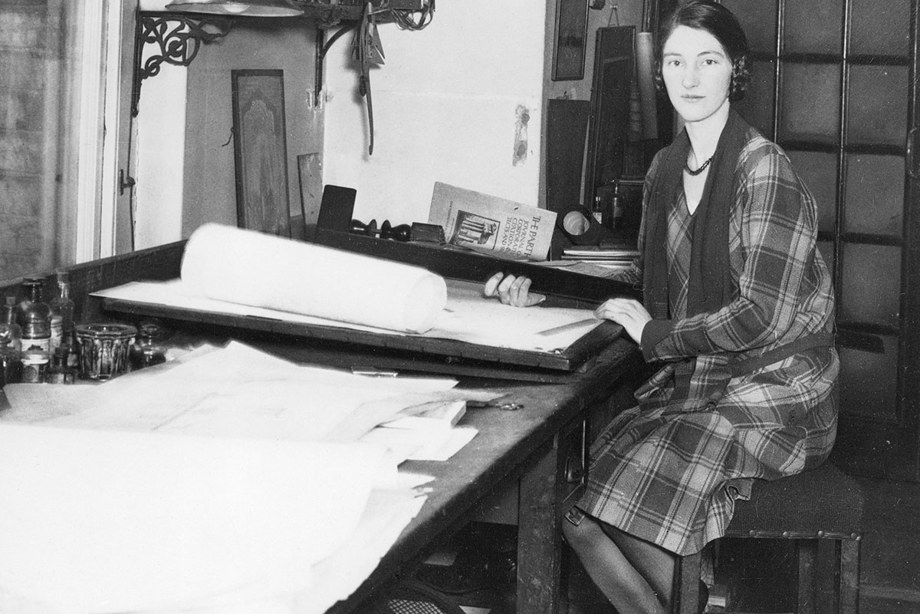 Architect Kathleen Veitch sits at a her drafting table, looking at the camera