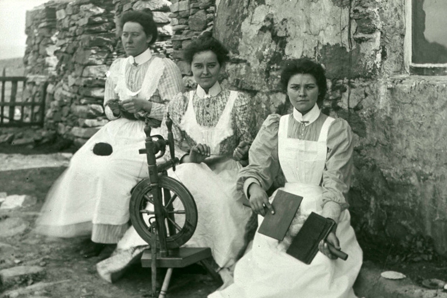 Three women undertaking tasks in the production of wool, 