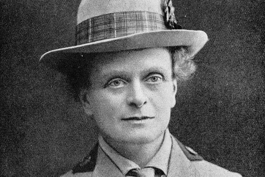 A woman wearing a miliary fashion jacket and a hat.