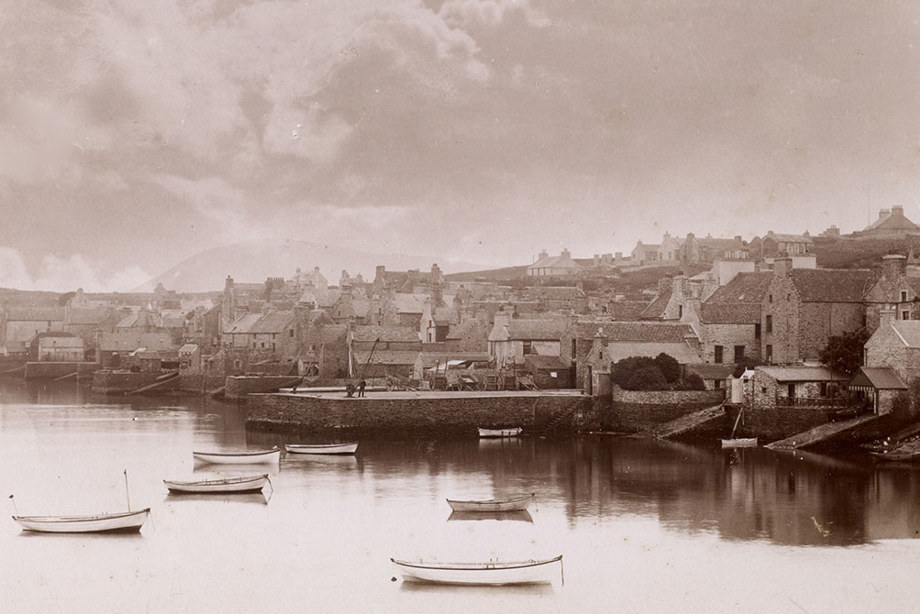 A harbour town with boats and houses at the seafront.