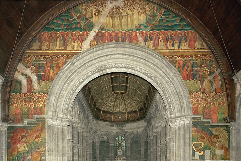 The interior of a church building, covered in colourful murals and artworks.