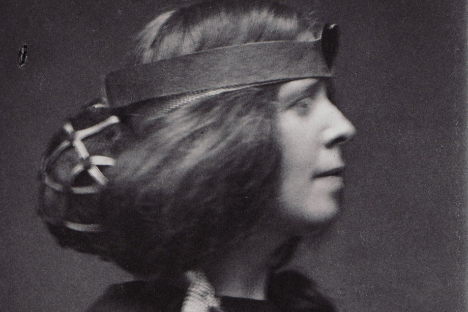 Margaret Maconald wearing an extravagant hairstyle and unusual clothing