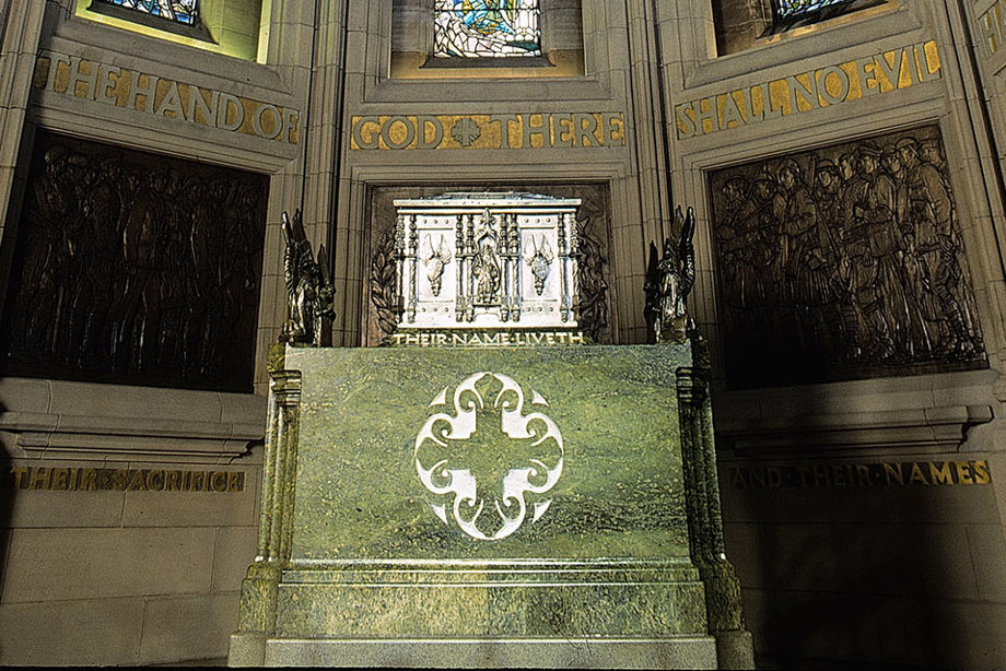 A shrine in a room, with bronze engravings on the wall depicting soldiers 