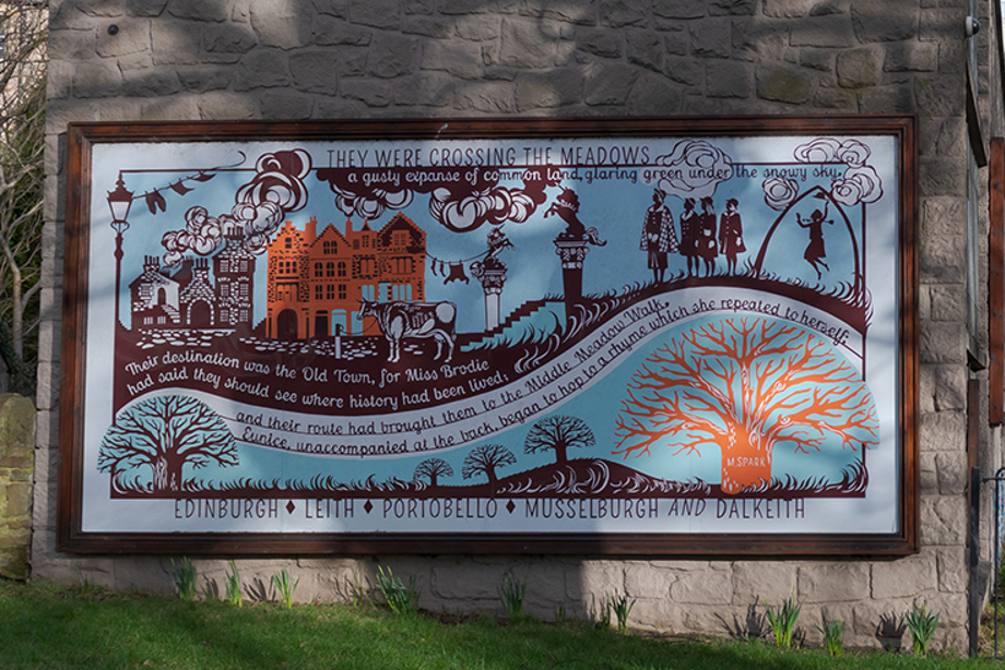 A colourful mural mounted on the side of a wall in a park