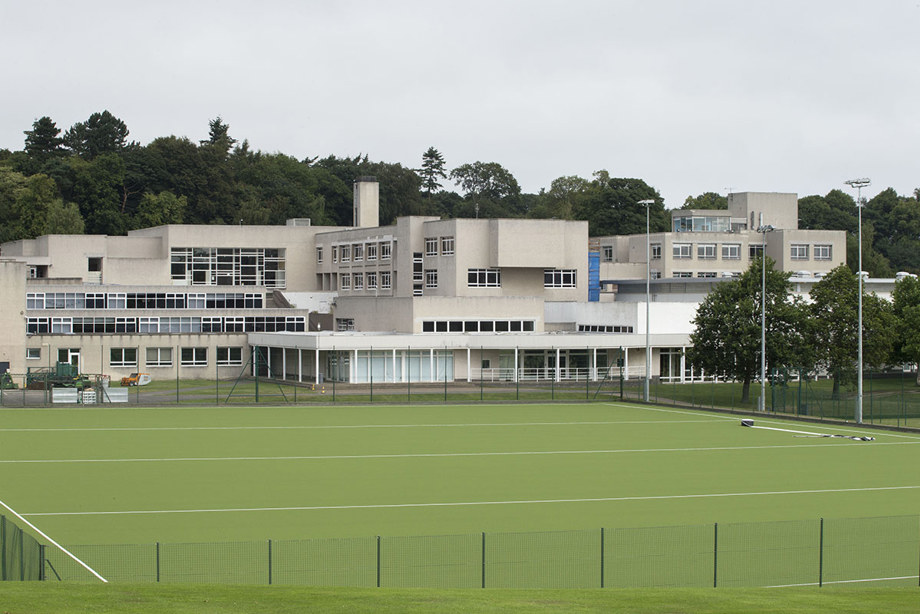 A school block set behind a playing field.