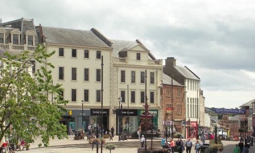 View of the high street in Dumfries with a pedestrianised square and shops