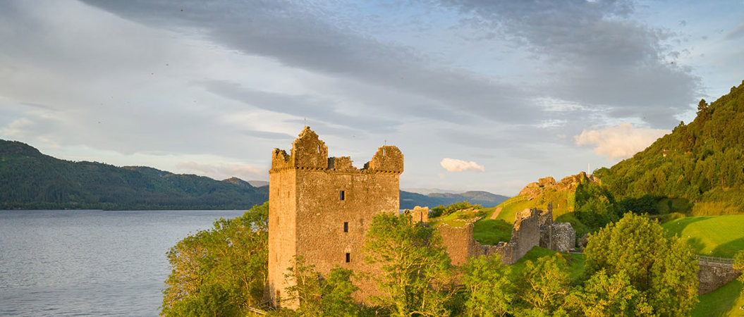 Urquhart Castle beside the water on a sunny evening