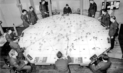An archive photo of military strategists planning around a large circular table 