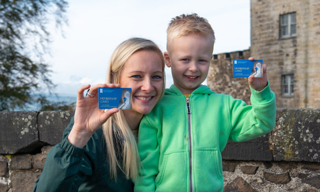 Mother and son holding up their membership cards at Stirling Castle