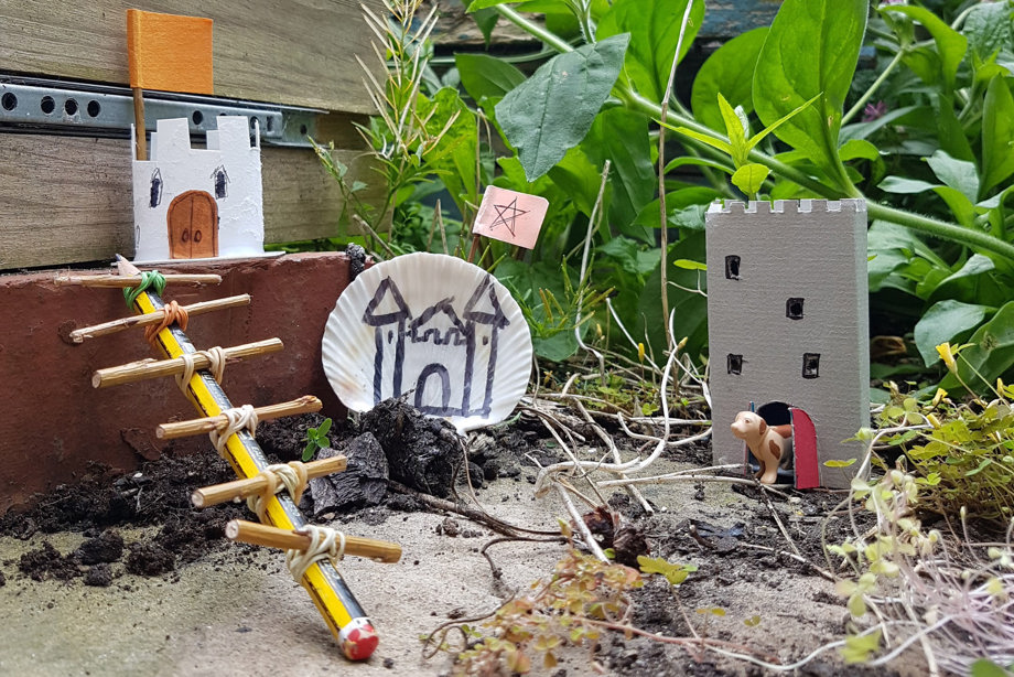 Tiny homemade castles in the garden surrounded by greenery